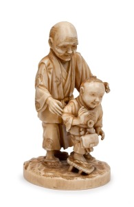 A Japanese carved ivory okimono figural group of a man and child, Meiji Period, 19th/20th century, with red seal mark to base, 10cm high.
