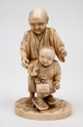 A Japanese carved ivory okimono figural group of a man and child, Meiji Period, 19th/20th century, with red seal mark to base, 10cm high. - 2