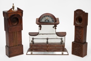 Two antique carved timber folk art pocket watch holders in the form of longcase clocks; together with an antique folk art mirrored wall shelf, 19th/20th century, (3 items), the largest 32cm high.