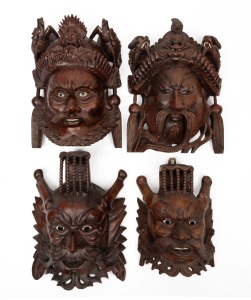 Four vintage Chinese carved wooden face mask ornaments with glass inlaid eyes and carved bone teeth, 20th century, the largest 27cm high.