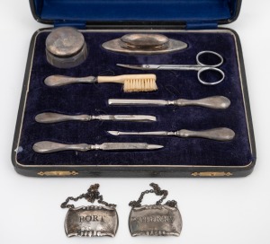 An antique English sterling silver and bone manicure set in original fitted box; together with a pair of port and sherry decanter labels, 20th century, the box 21cm wide.