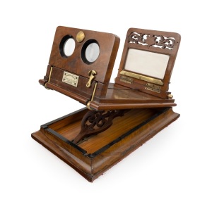 Stereo graphoscope incorporating stereo viewer on hinged platform, c. 1870s, with carved floral details and "Negretti & Zambra - Opticians to the Queen - 122 Regent Street London" retailer's plaque; 40 x 23 x 33cm at maximum height.