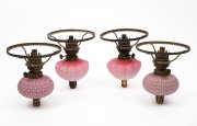 Two pairs of antique pink glass piano oil lamps, 19th/20th century, 18cm high, 14cm diameter.