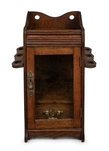 An antique English oak humidor smoker's cabinet with gilt metal fittings and drop-side pipe holders, late 19th century, 32cm high.