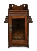 An antique English oak humidor smoker's cabinet with gilt metal fittings and drop-side pipe holders, late 19th century, 32cm high.