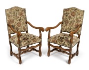 A pair of reproduction French style armchairs with carved beech frames and floral tapestry upholstery, 20th century in the 18th century style, 110cm high, 59cm across the arms.