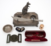 Antique gold finished spectacles, silver dish, silver plated kangaroo ink stand, antique gold plated match vesta, antique sterling silver thimble in case, antique British military belt buckle and a trench art paper knife, 19th and 20th century, (7 items),
