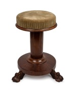 An antique English mahogany revolving piano stool with carved claw feet, circa 1835, 48cm high, 32cm diameter.