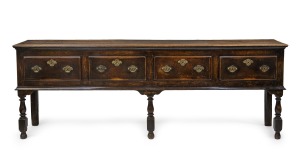 An antique English oak four drawer dresser base with original brass hardware and baluster turned legs, 18th century, 84cm high, 241cm wide, 45cm deep.