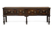 An antique English oak four drawer dresser base with original brass hardware and baluster turned legs, 18th century, 84cm high, 241cm wide, 45cm deep.