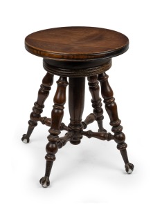 An antique American black walnut revolving piano stool with cast metal and glass claw feet, 19th/20th century, ​​​​​​​45cm high, 36cm diameter.