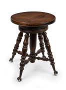 An antique American black walnut revolving piano stool with cast metal and glass claw feet, 19th/20th century, ​​​​​​​45cm high, 36cm diameter.