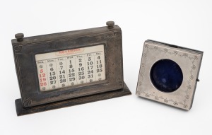 An antique sterling silver mounted desk calendar; together with an antique sterling silver pocket watch holder, 20th century, (2 items), the calendar 21cm wide.