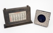 An antique sterling silver mounted desk calendar; together with an antique sterling silver pocket watch holder, 20th century, (2 items), the calendar 21cm wide.