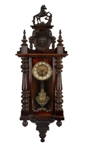 An antique German wall clock in ornate walnut case, eight day time and strike movement with Art Nouveau pressed brass pendulum and dial mask, late 19th century, 100cm high.