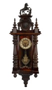 An antique German wall clock in ornate walnut case, eight day time and strike movement with Art Nouveau pressed brass pendulum and dial mask, late 19th century, 100cm high.
