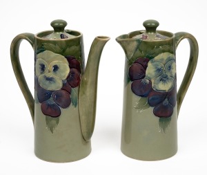 MOORCROFT rare and early "Pansy" pattern teapot and companion hot water pot on celadon green ground, (2 items), both impressed "MOORCROFT BURSLEM" with green signature "W. Moorcroft", 15.5cm high.