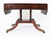An antique Regency mahogany sofa table, the cantered corner mahogany top crossbanded with rosewood, ebony and boxwood stringing, two drawers to the frieze, turned support base with quadraform splay legs terminating on brass lion paw castors, circa 1825, 7 - 3