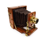 LANCASTER: "Instantograph" view camera, late 19th century, plate dimensions 11.5 x 16.5cm, fixed-aperture Lancaster brass lens, burgundy bellows, unusual rear hinge mechanism.