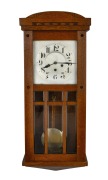 A German oak cased wall clock with three train chime and gong strike movement, silvered dial with Arabic numerals, early 20th century, 67cm high.
