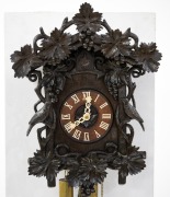 An antique German Black Forest cuckoo wall clock in ebonised linden wood case with grape vine and fruit carved decoration and two carved cuckoos, fretted carved bone hands with Roman numerals, 30-hour wood plate movement striking the half and hours on the - 2