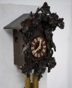 An antique German Black Forest cuckoo wall clock in ebonised linden wood case with grape vine and fruit carved decoration and two carved cuckoos, fretted carved bone hands with Roman numerals, 30-hour wood plate movement striking the half and hours on the - 3