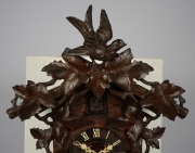 An antique German Black Forest cuckoo wall clock in carved case with vine leaf decoration and cuckoo finial. Fancy fretted and carved bone hands, plus Roman numerals. 30 hour brass plate movement striking the hour and half hour on a coil gong, circa 1890, - 2