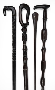 Four assorted carved ebony walking sticks, Indian, Papua New Guinea and Pacific Islands, 20th century, the largest 95cm long.