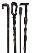 Four assorted carved ebony walking sticks, Indian, Papua New Guinea and Pacific Islands, 20th century, the largest 95cm long.