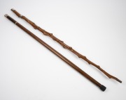 An antique walking stick with yucca shaft, brass ferrule, silver top and collar, engraved "Yucca, August 31st, 1906"; together with a vintage secret drinking stick with glass vial and miniature goblet, 20th century, (2 items), ​​​​​​​92cm and 86cm high. - 2