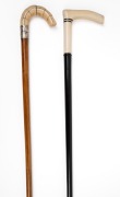 Two antique walking sticks with carved ivory handles, ebony and malacca shafts, (one with silver collar), 19th/20th century, 91cm and 92cm high.