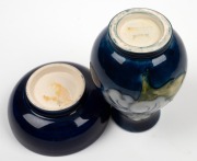 MOORCROFT English miniature pottery vase with floral decoration on blue ground; together with a matching bowl, (2 items), factory mark to base, the vase 9cm high. - 2