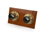 Stereo brass lens pair with iris diaphragms, mounted on board, late-19th century, both engraved "Harrington & Co - Photographic Merchants - Sydney".