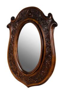 Australian shield shaped Arts & Crafts mirror in blackwood frame carved with gumnuts & leaves. 82 x 60cm