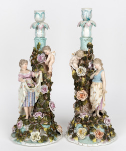 A pair of antique German porcelain figural candlesticks with applied floral decoration, 19th century, 41cm high.