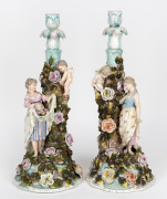 A pair of antique German porcelain figural candlesticks with applied floral decoration, 19th century, ​​​​​​​41cm high.