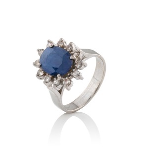 A vintage 14ct white gold ring, set with an Australian blue sapphire surrounded by twelve brilliant cut white diamonds, 20th century, 4.2 grams.