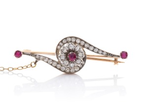 An Art Deco 18ct gold, diamond and ruby brooch, circa 1930s, housed in plush fitted box branded "W.W. PADGELT, The Arcade Market Place, Newark", 4.8cm wide, 6.8 grams.