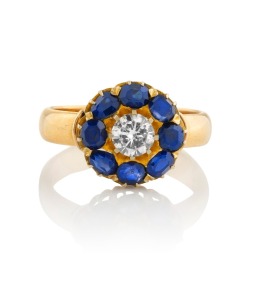 An antique 9ct gold ring, set with an impressive white diamond surrounded by eight blue sapphires, 19th/20th century, stamped "375", 5.1 grams.