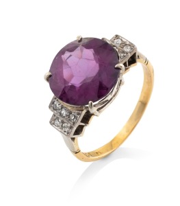 A vintage 18ct gold ring with impressive purple sapphire flanked by white diamonds mounted in white gold, early to mid 20th century, 6.3 grams.