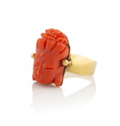An antique French 18ct gold ring with carved coral chinoiserie decoration, early 20th century, 7.8 grams total.