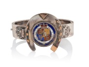 An antique sterling silver bangle with horseshoe decoration, highlighted in 9ct rose gold with enamelled George IV coin, 19th century, 31 grams total.