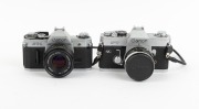 CANON: Pair of 1960s SLRs, comprising Canon FT QL (FL 50mm f1.8, with cap and leather case) and Canon AT-1 (FD 50mm f1.8). (2 items) - 2