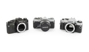 OLYMPUS: Group of 1970s SLRs, comprising Olympus OM-1 (F. Zuiko Auto-S 50mm f1.8, with cap and leather case), Olympus OM10 (body only), and Olympus OM20 (body only). (3 items)