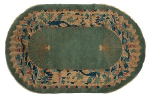 A vintage Chinese Art Deco oval wool rug on blue ground. Fair condition only with margins severely trimmed, some stains and losses. 240 x 150cm overall.