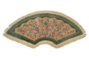 A Chinese Art Deco fan shaped floral wool rug on celadon green ground, 68 x 131cm.