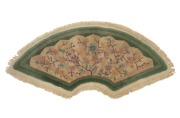 A Chinese Art Deco fan shaped floral wool rug on celadon green ground, 68 x 131cm.