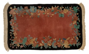 A Chinese Art Deco floral pattern wool rug on black and pink ground, 164 x 92cm.