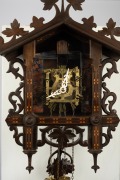 An antique German Black Forest railway cuckoo wall clock in carved and fretted linden wood case with Tunbridge style parquetry banding, later fitted transparent dial plate displaying the fretted brass plate 30 hour movement, cuckoo and bellows, circa 1900 - 2