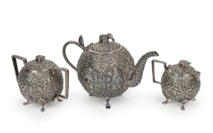 An antique three piece Anglo-Indian Cutch silver tea service, handsomely decorated with scrolling floral motif and elephant finials, circa 1880, the teapot 16cm high, 23cm wide, 1155 grams total.